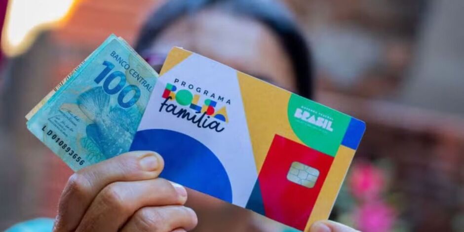 Mulher segurando cart&atilde;o e benef&iacute;cio do Bolsa Fam&iacute;lia.