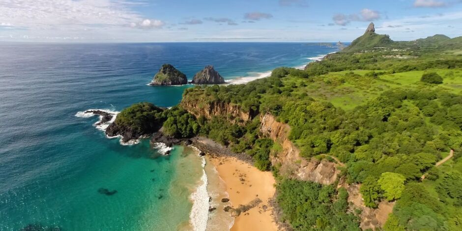 Vista da Ba&iacute;a do Sancho, com fal&eacute;sias e mar cristalino que marcam a paisagem de Fernando de Noronha.