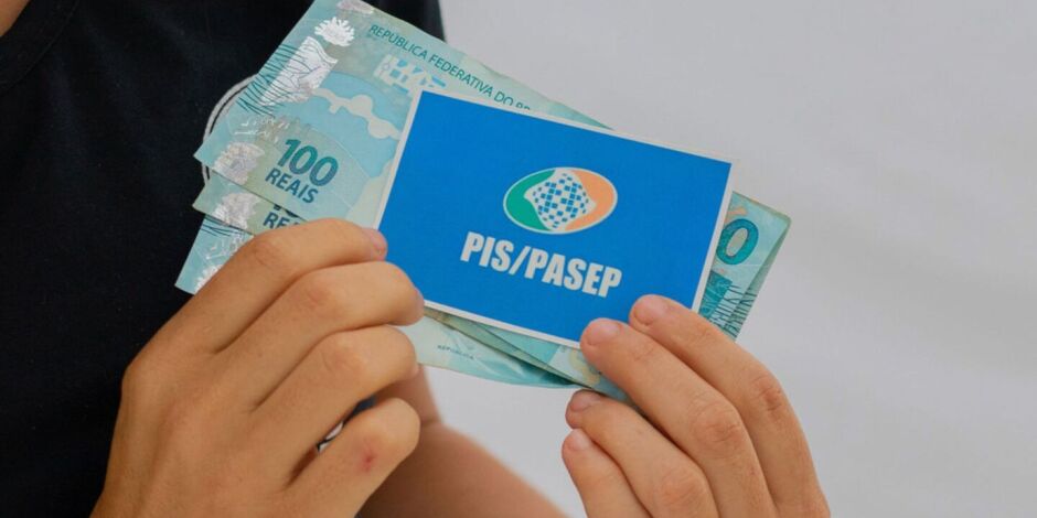 Pessoa com cart&atilde;o do PIS/Pasep e dinheiro do abono.