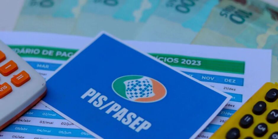 Cart&atilde;o do PIS/Pasep ao lado de dinheiro do abono e calculadoras.