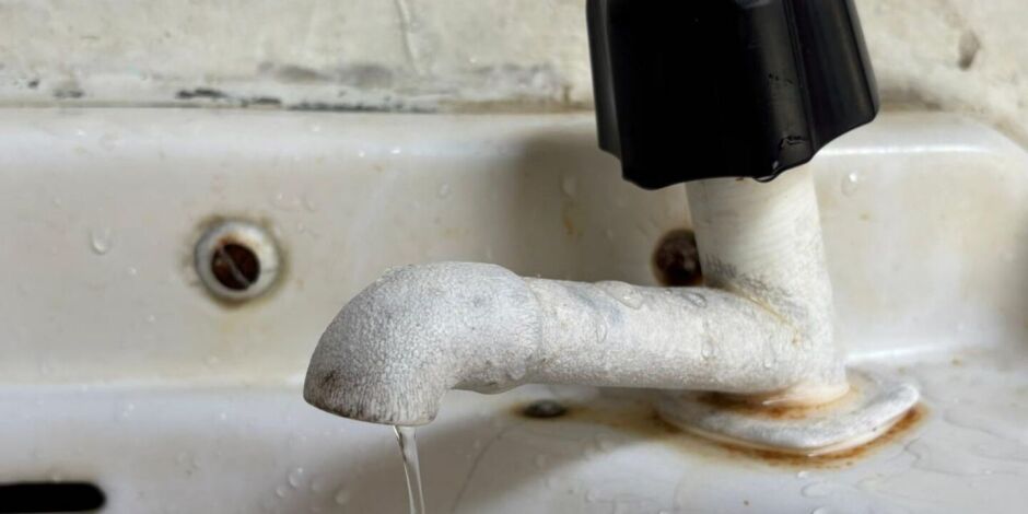 Torneira aberta vazando &aacute;gua.