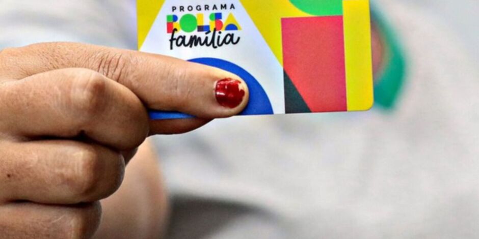 Mulher segurando cart&atilde;o do Bolsa Fam&iacute;lia.