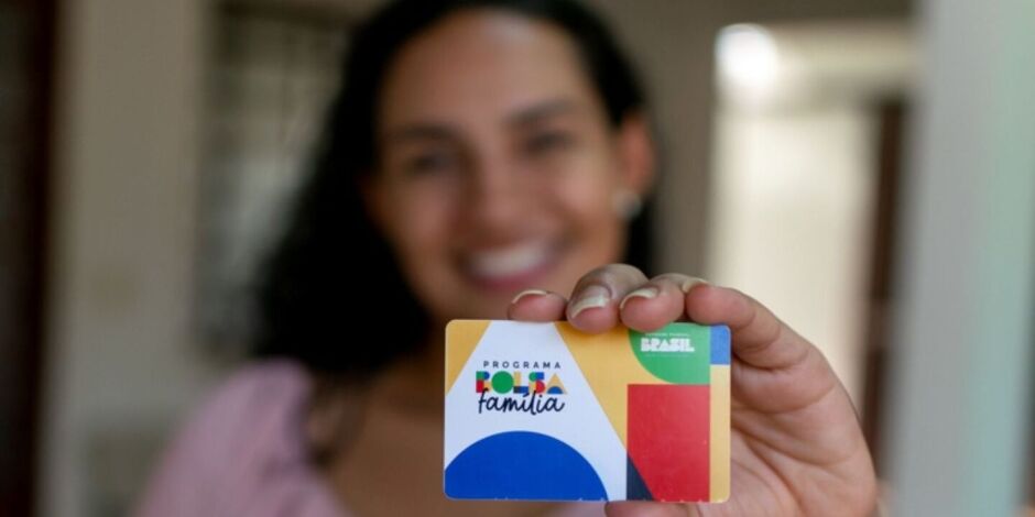 Mulher segurando cart&atilde;o do Bolsa Fam&iacute;lia.