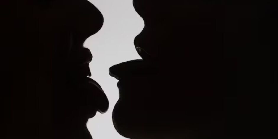 Silhuetas de pessoas se beijando.