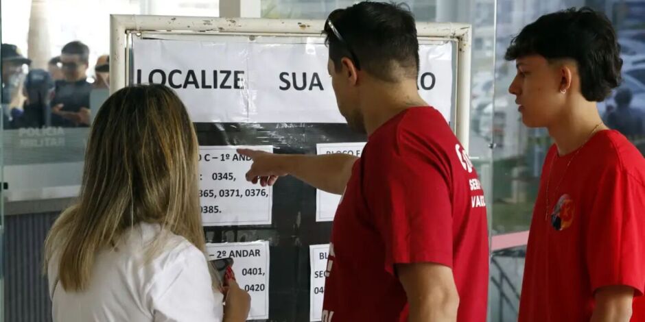 Eleitores consultando se&ccedil;&atilde;o de vota&ccedil;&atilde;o.