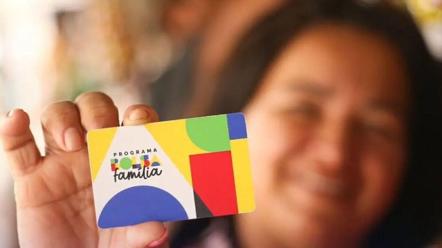 Mulher com cartão do Bolsa Família.