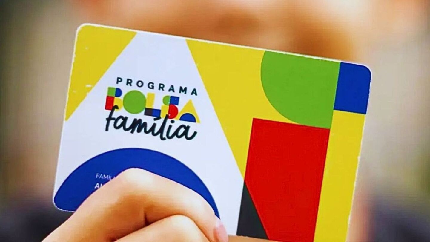Pessoa segurando cartão do Bolsa Família.
