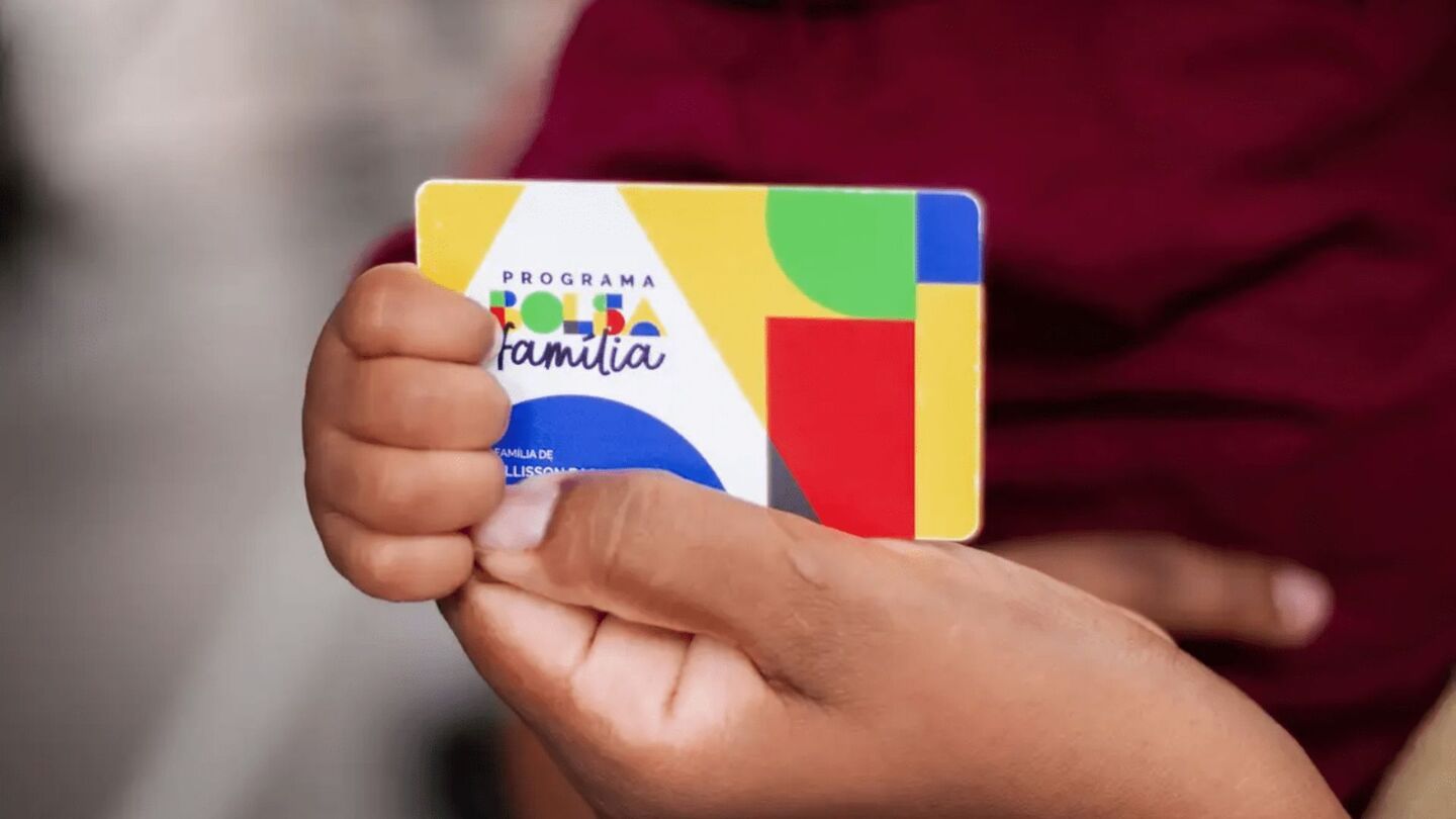 Pessoa segurando cartão do Bolsa Família.
