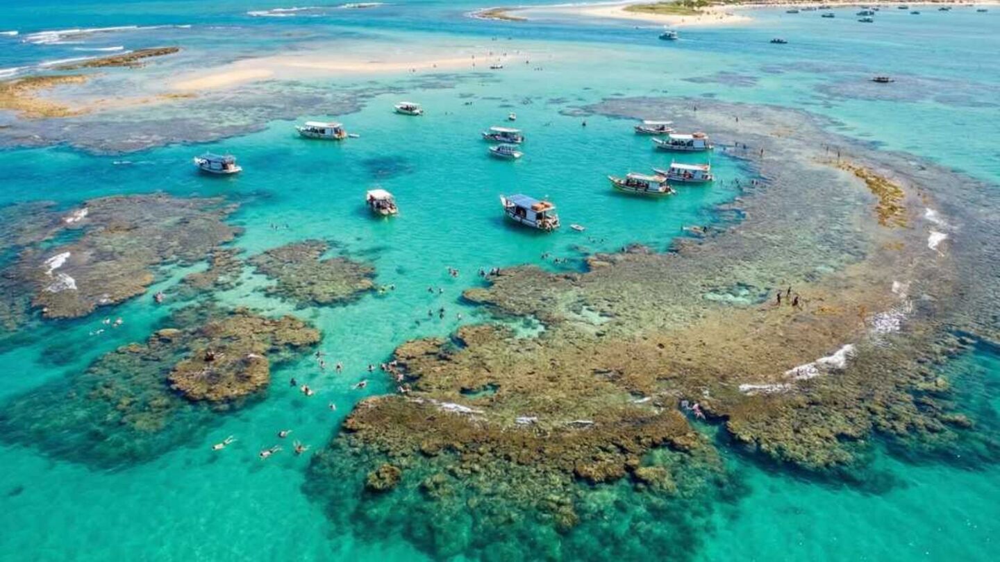 A praia é cercada de recifes gigantes em alto-mar.